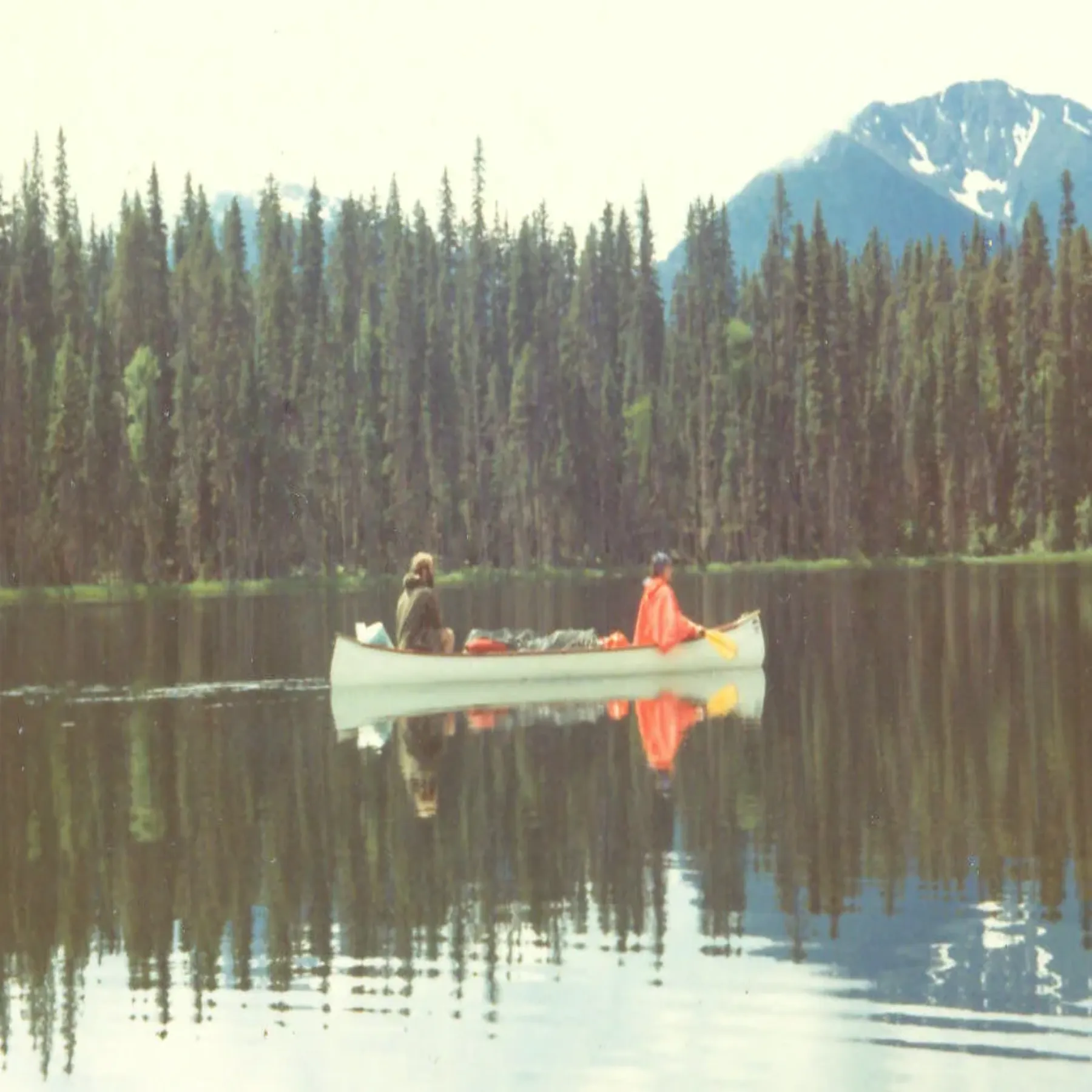Una canoa en un lago rodeado de bosque durante el circuito de Bowron Lake.