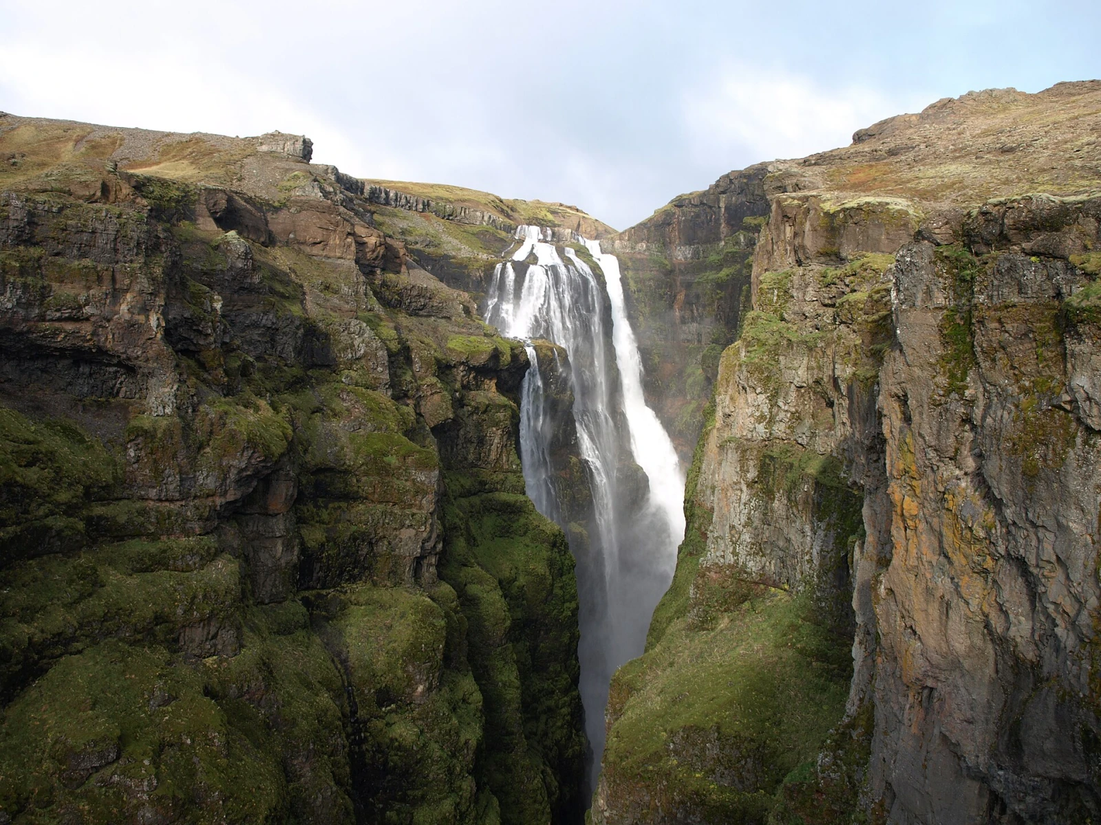 Glymur waterfall plunging through a steep green Icelandic canyon.