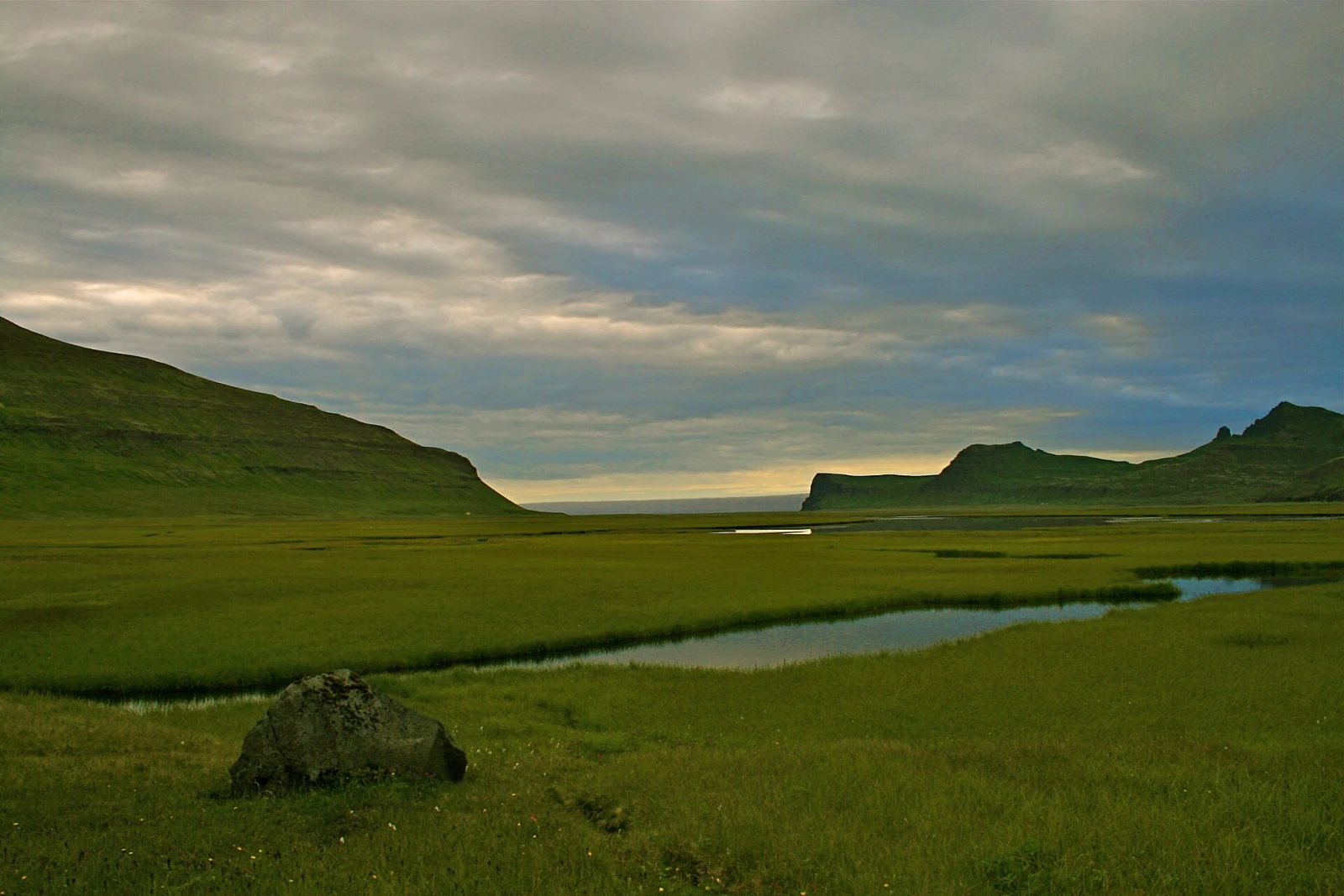 Remote green marshes and mountains in Iceland's roadless Hornstrandir reserve.