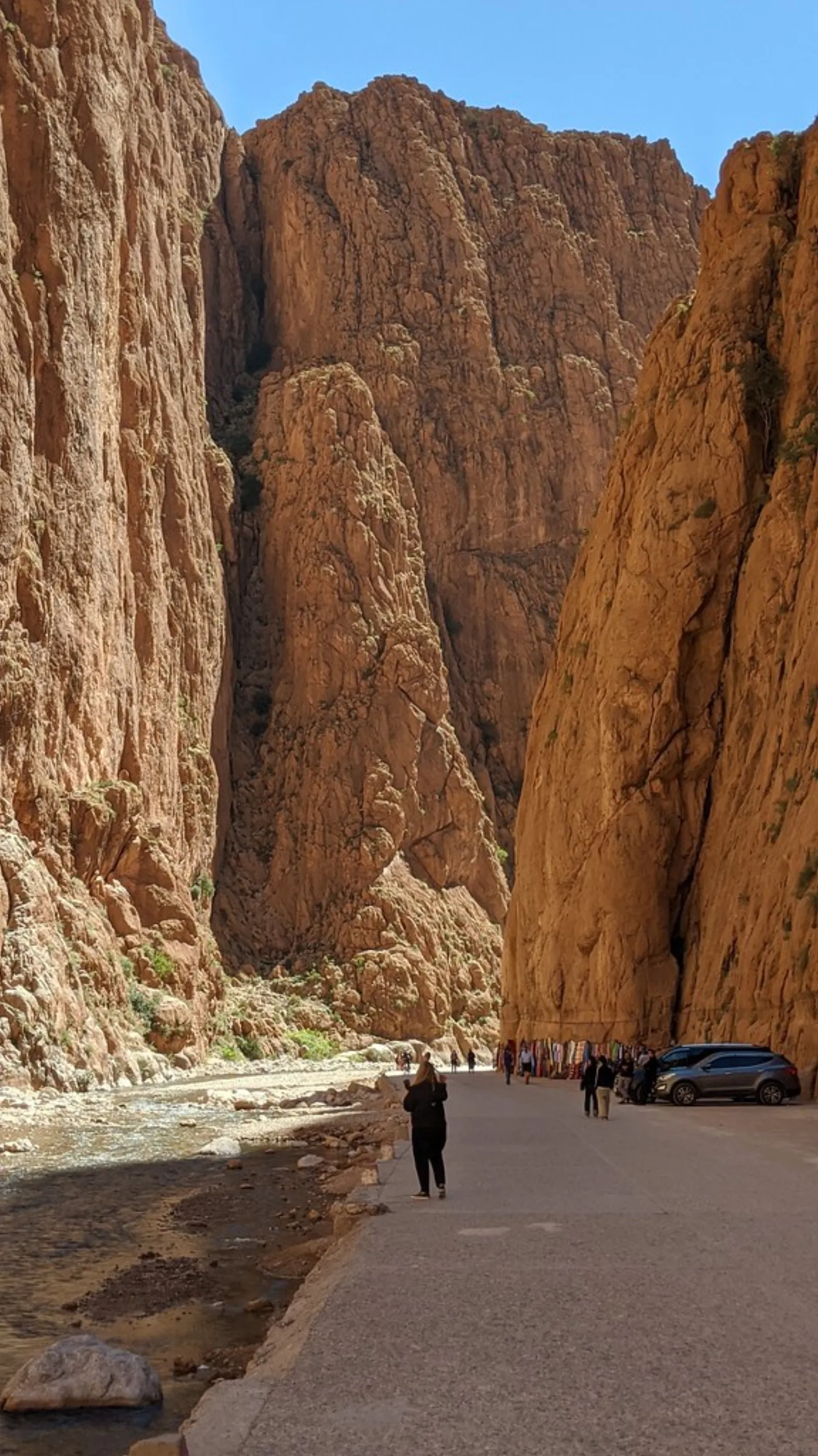 Visitors walking beneath the cliffs of Todgha Gorge, Morocco