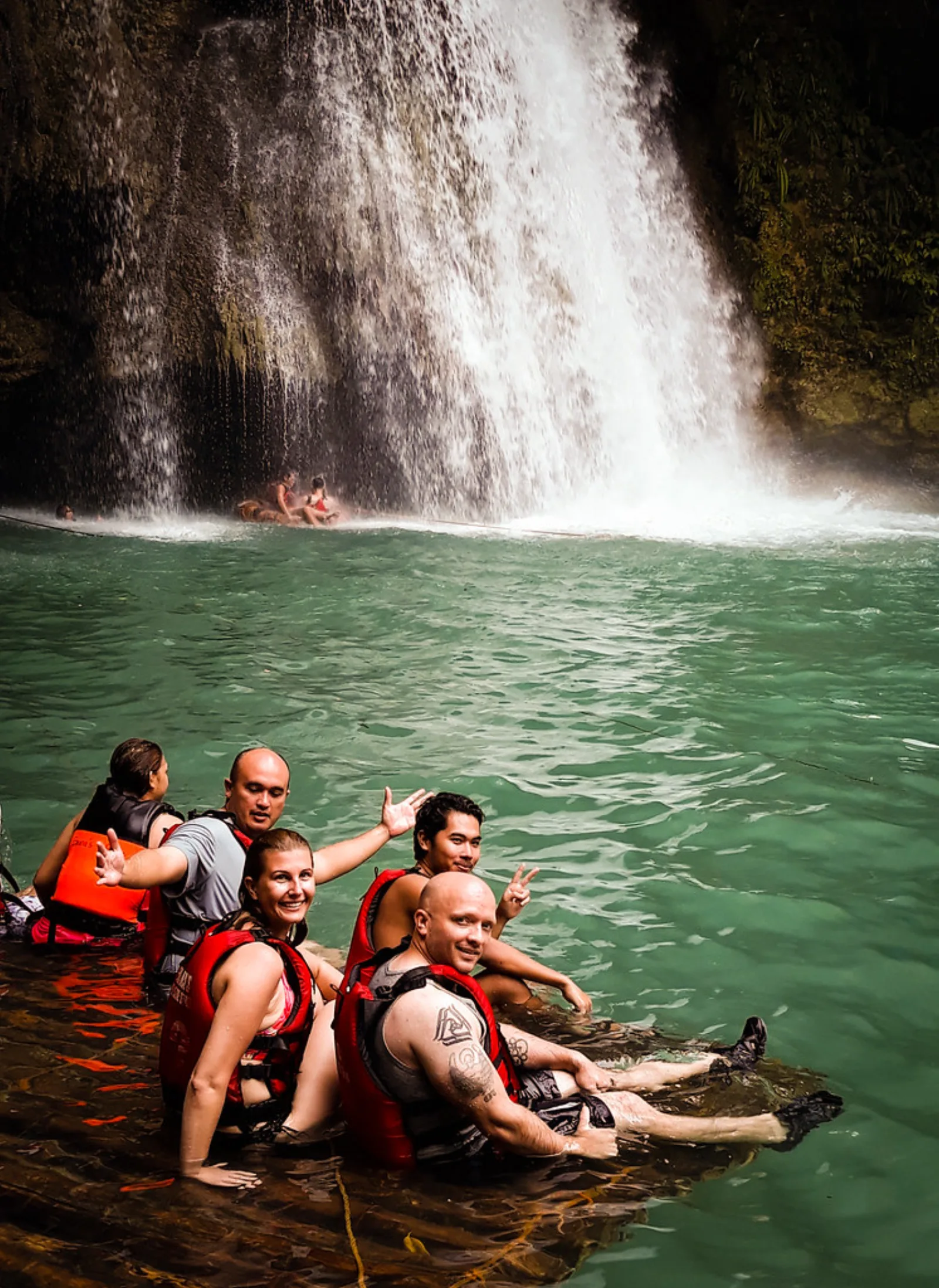 Barranquistas se bañan bajo la cascada Kawasan, en Badian.