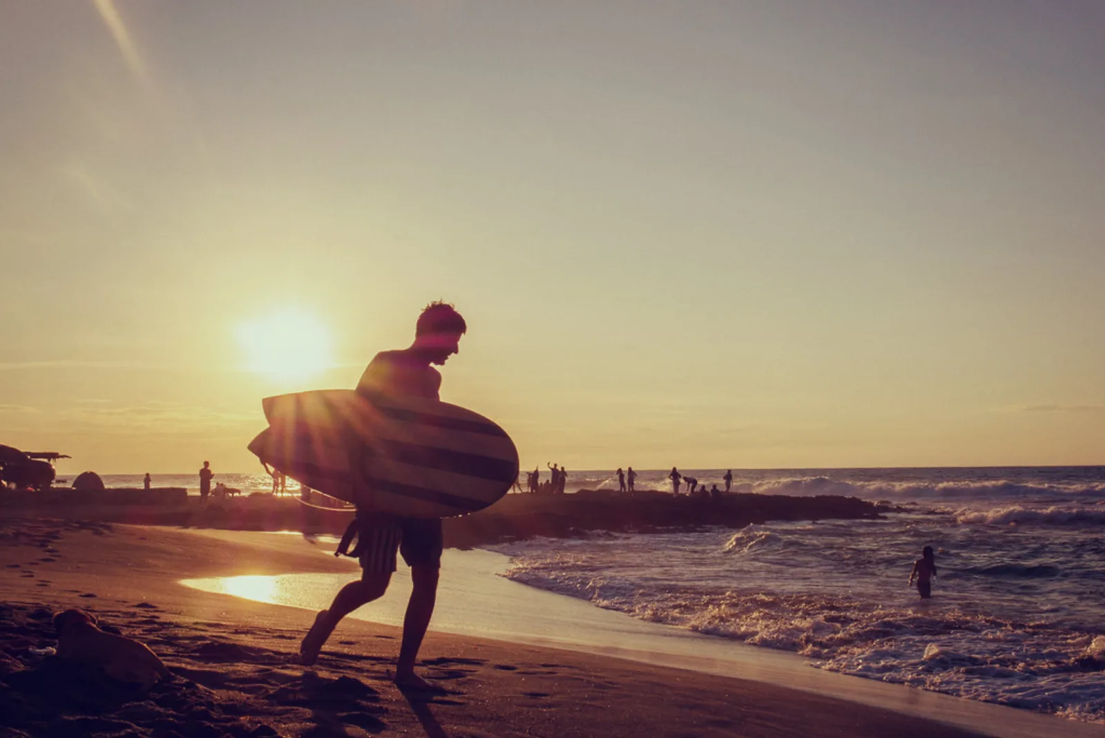 Un surfista camina hacia las olas de La Union.