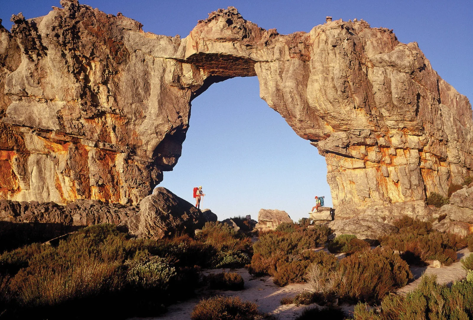 Hikers beneath Wolfberg Arch in the Cederberg.