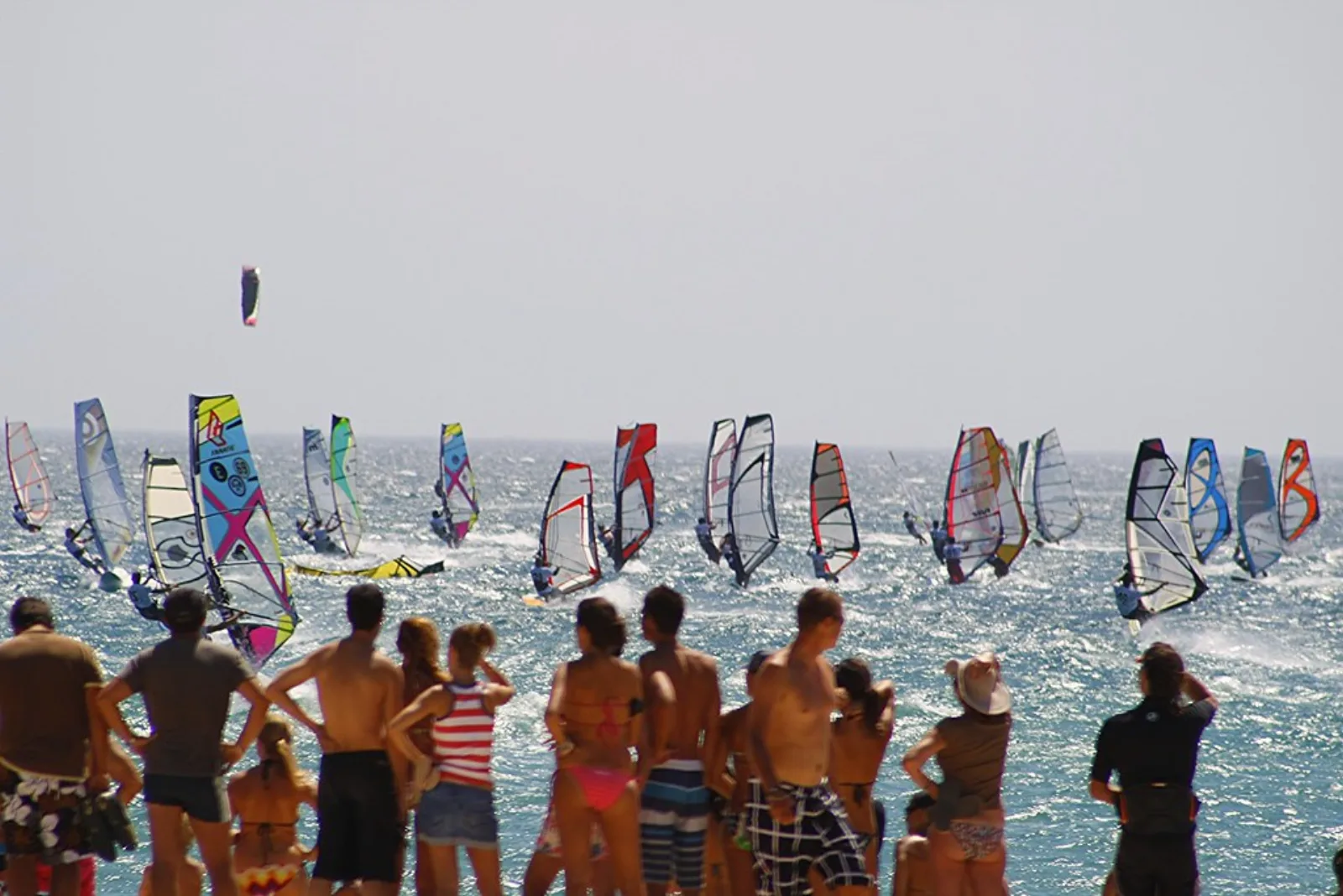 Windsurfistas navegando frente a Tarifa con fuerte viento costero.