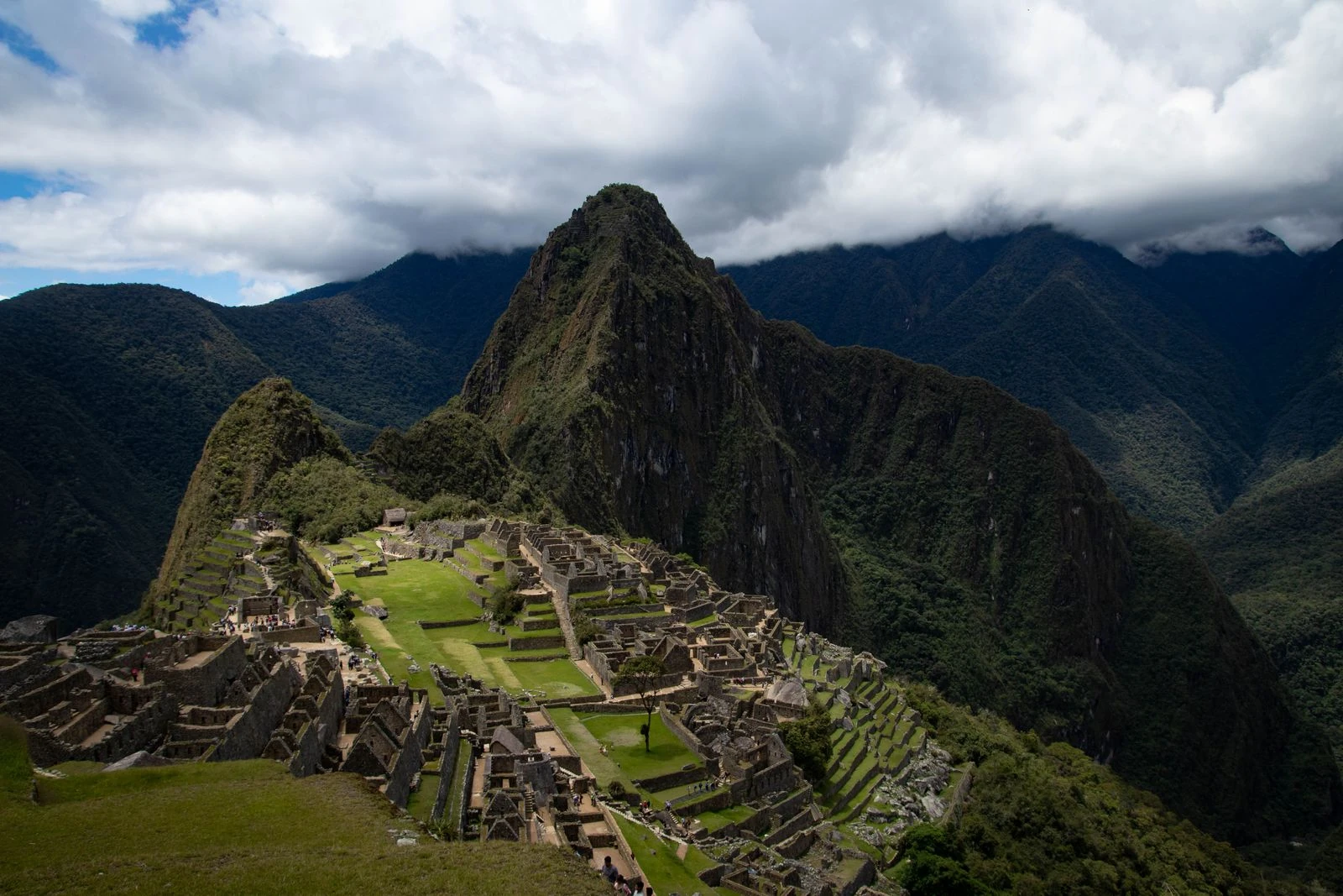 Machu Picchu and Huayna Picchu beneath a bank of dramatic clouds.