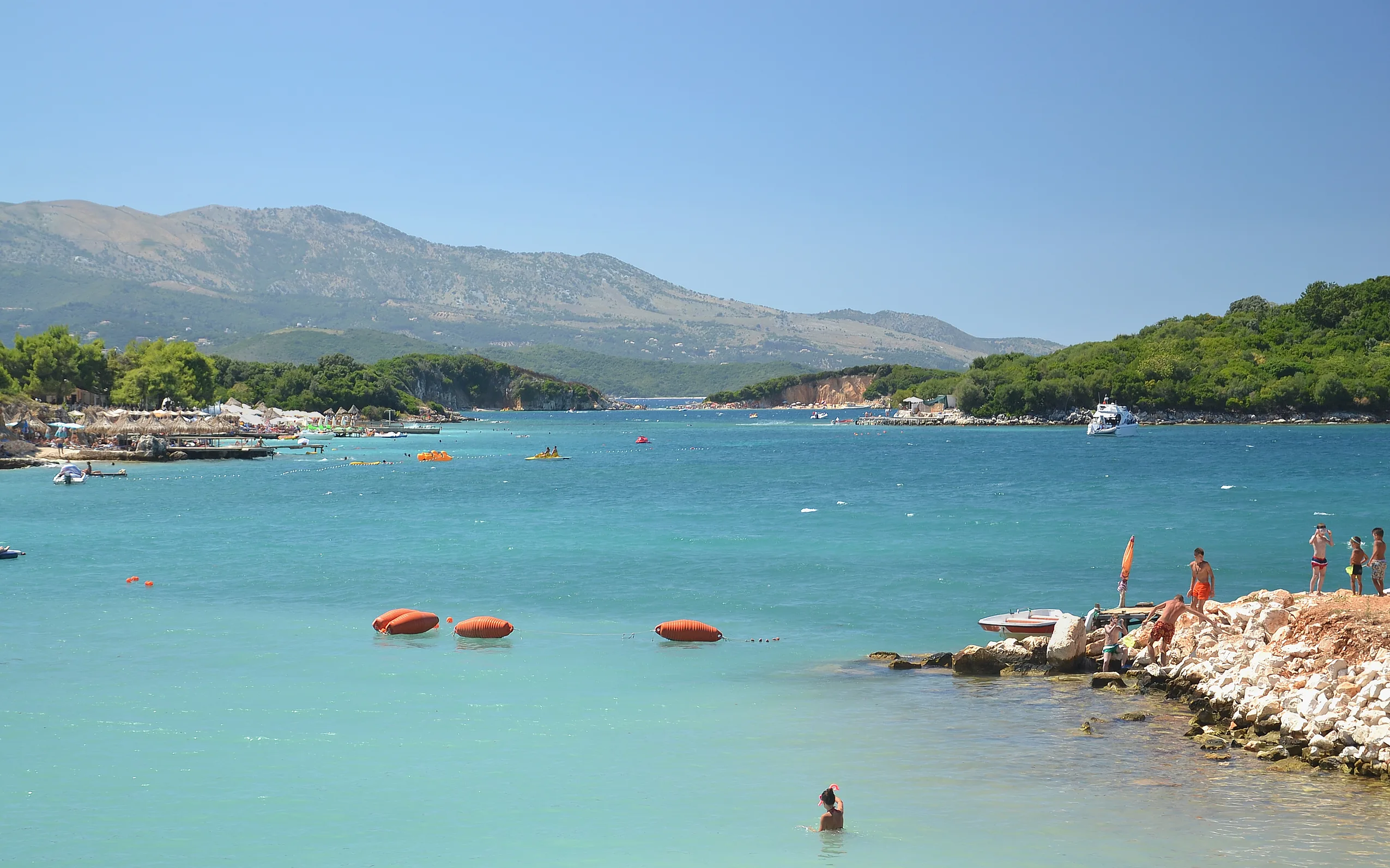 Turquoise water, small wooded islands and swimmers at Ksamil on Albania's far southern coast.