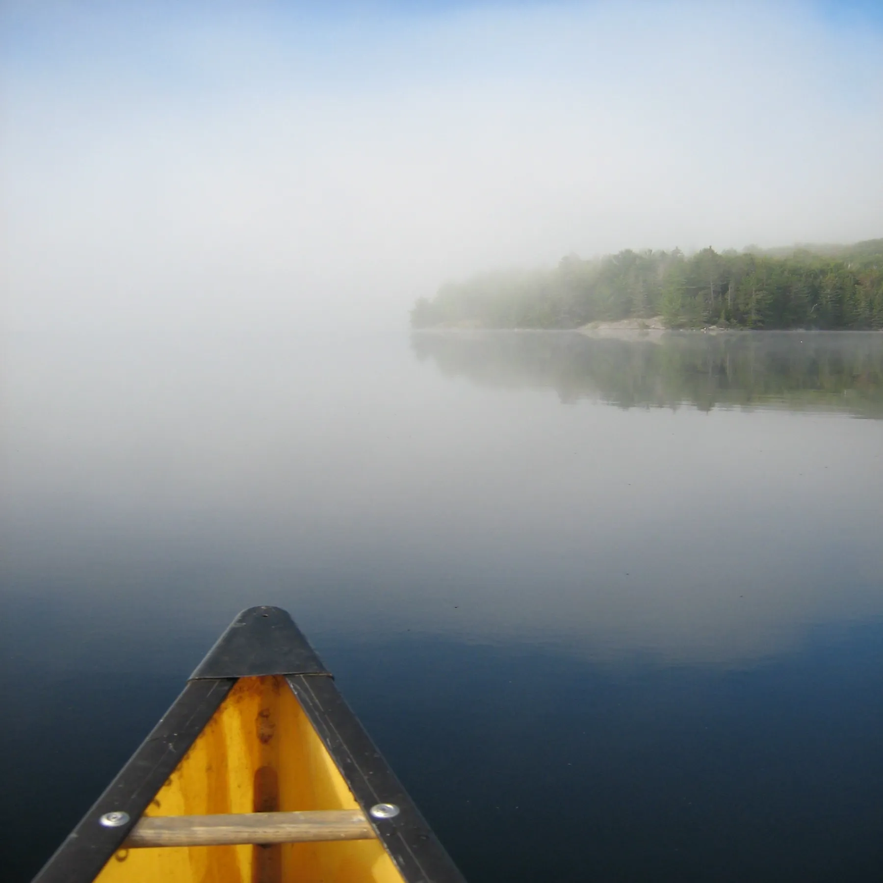 A canoe entering a misty lake in Algonquin Park.