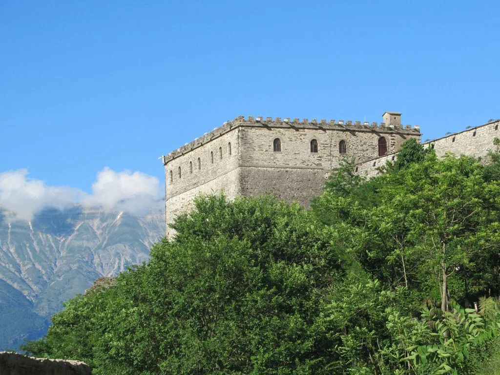 A crenellated stone bastion of Gjirokastër Castle above the Drino valley.