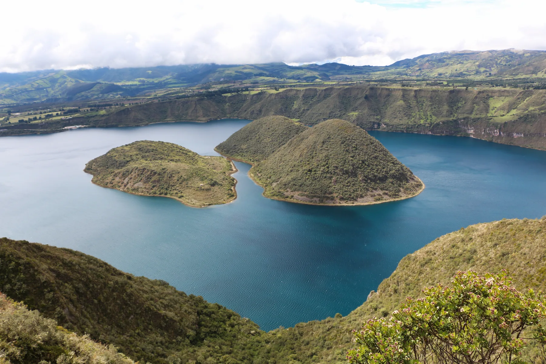 Cuicocha's twin islands rising from the blue crater lake beneath the Andean rim.