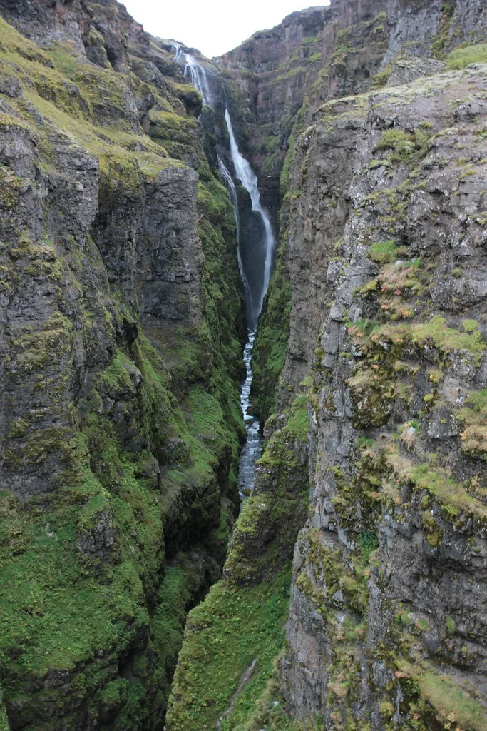 Glymur waterfall plunging through a narrow moss-covered canyon.