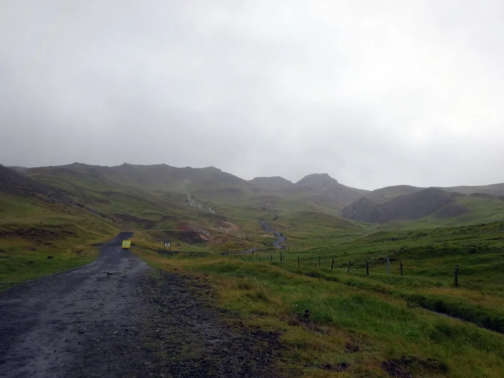 The path through Reykjadalur's green geothermal valley beneath low cloud.