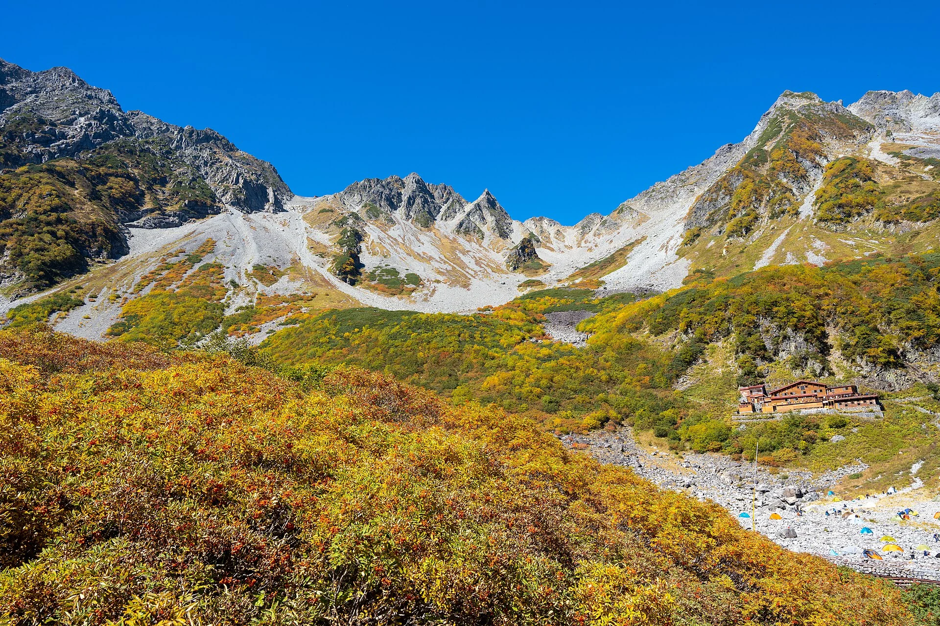 Autumn foliage filling the Karasawa Cirque beneath steep peaks in the Northern Alps.