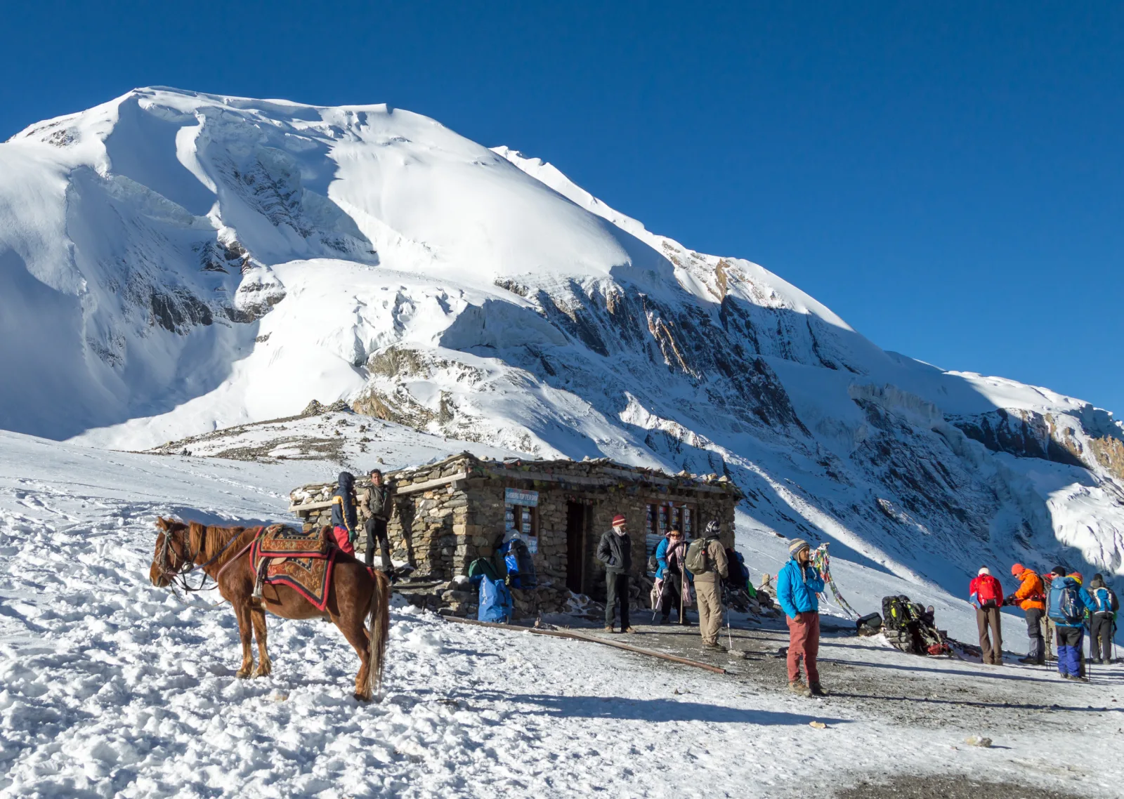 Trekkers and a teahouse at Thorong La on the Annapurna Circuit.