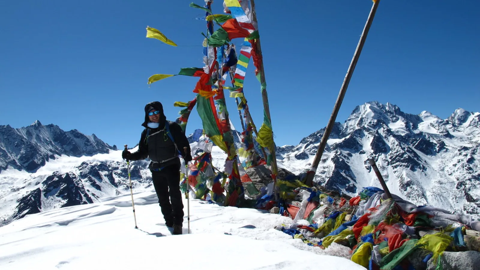 A hiker at the snowy summit of Tserko Ri.