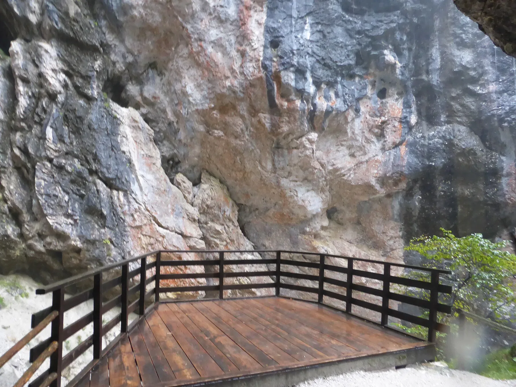 A boardwalk on the Soča Trail beside the rock walls of the Trenta Valley.