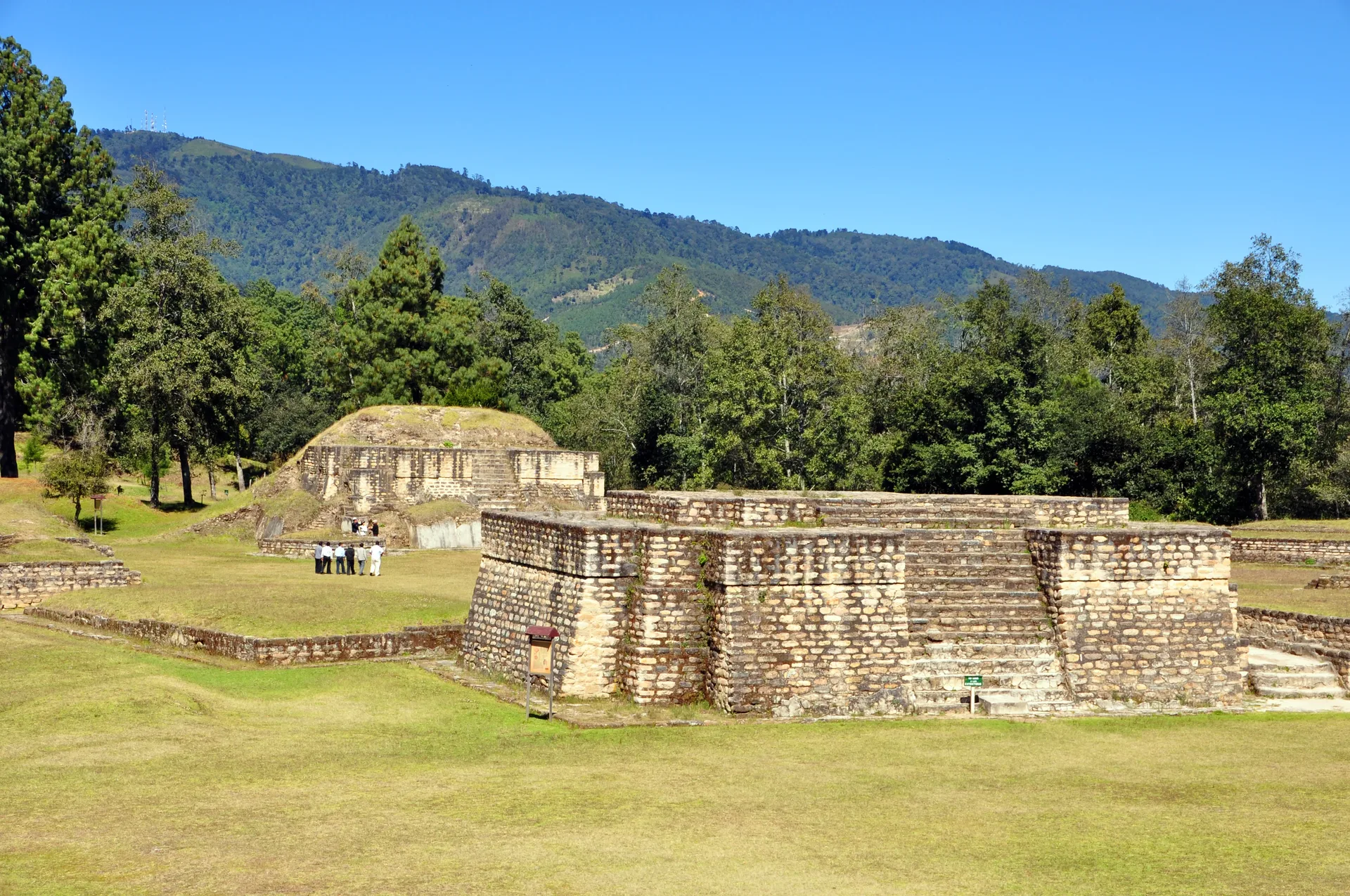 Stone temple platform and grassy plaza at Iximché in Guatemala's highlands.