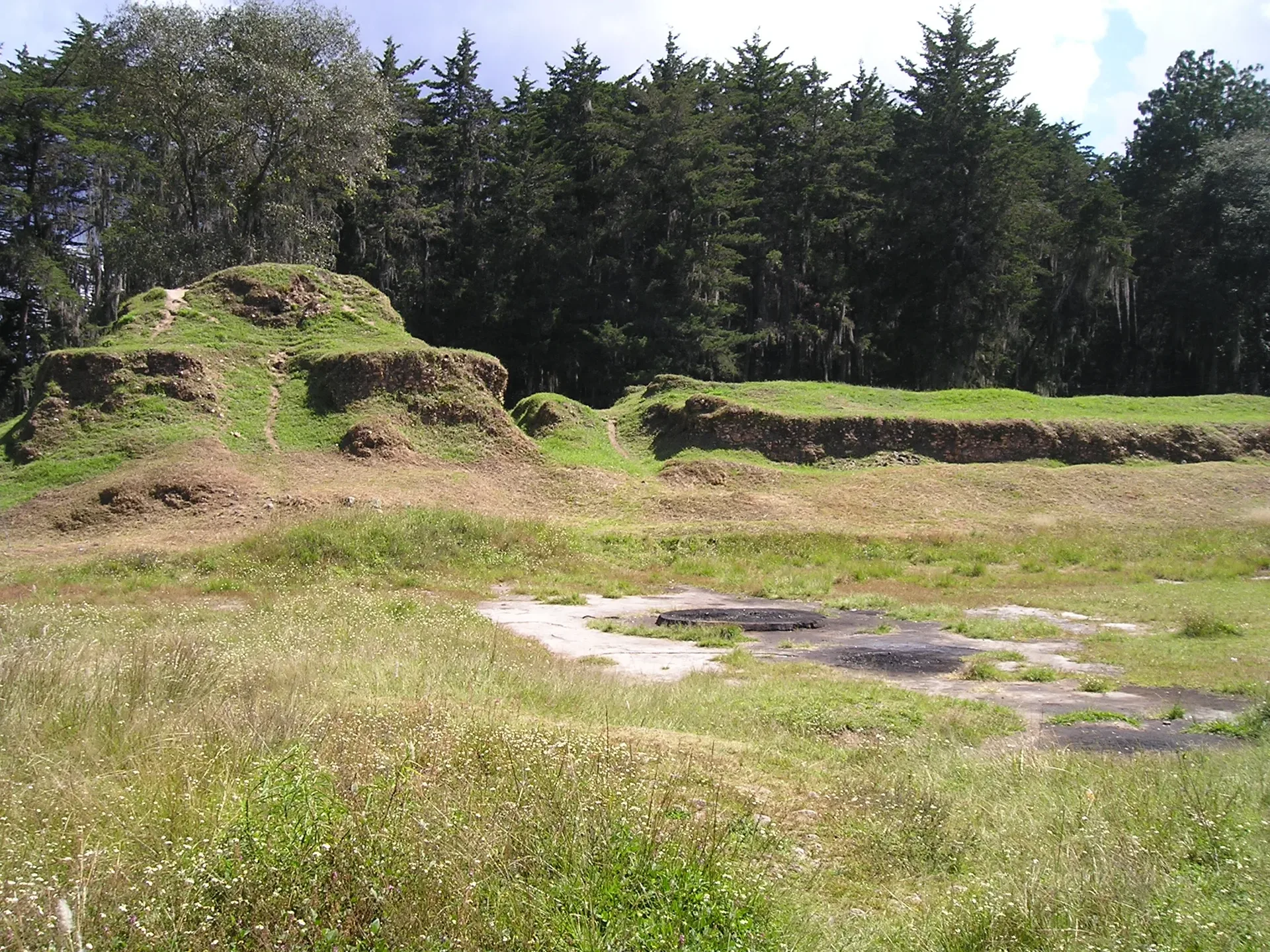 The Temple of Awilix standing in the grassy plaza at Q'umarkaj.