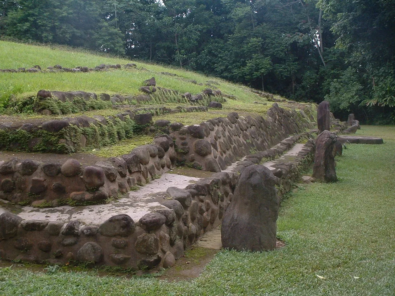 Stone monuments beside a grass-covered platform at Tak'alik Ab'aj.