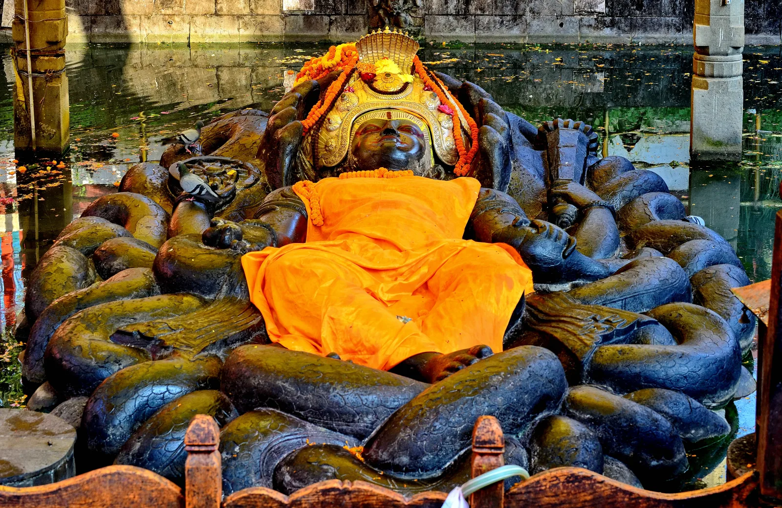 The reclining stone Vishnu at Budhanilkantha, decorated with orange cloth and flowers.